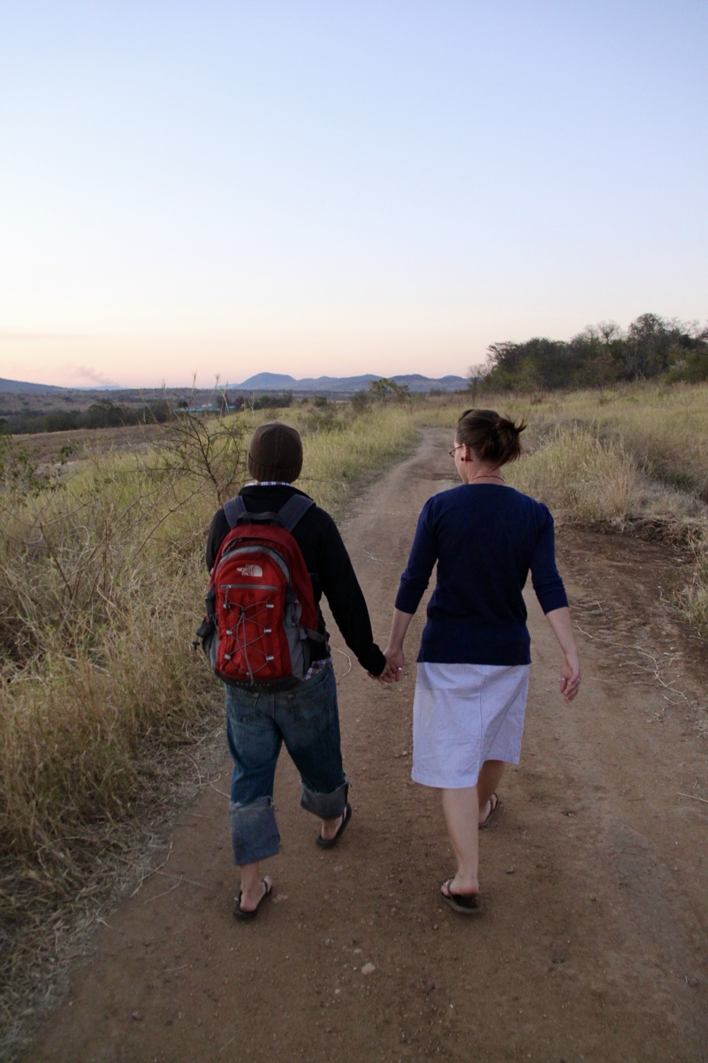 Nick and Traci walking hand in hand down a dirt road